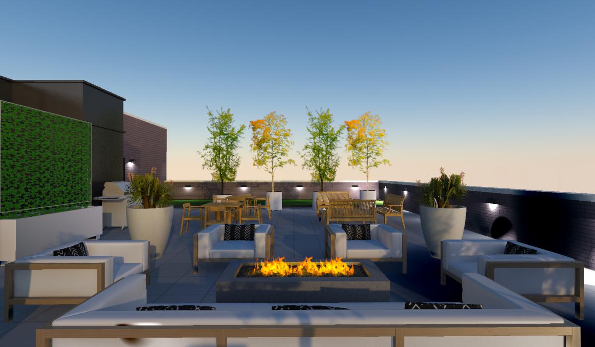 Straight on view of roof deck fire pit and seating with ornamental trees and dog run in background.